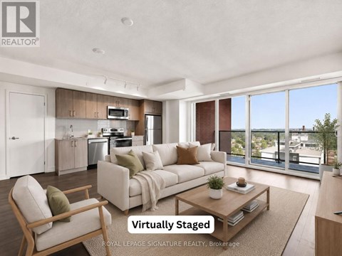 A modern living room with a kitchen in the background and a couch in the foreground.