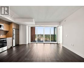 A spacious kitchen with dark wood floors and white walls.