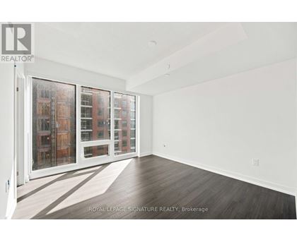 A white room with a sliding door and a view of a building outside.