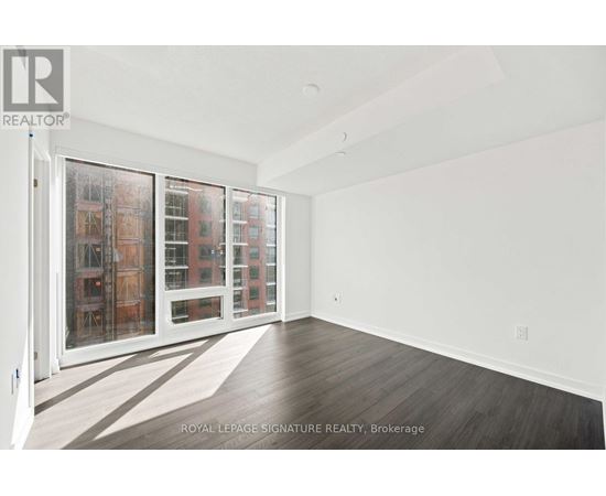 A white room with a sliding door and a view of a building outside.