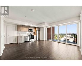 A spacious kitchen and living room with wooden floors and a view of the city.