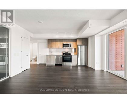 A spacious kitchen with white cabinets and a wooden backsplash.