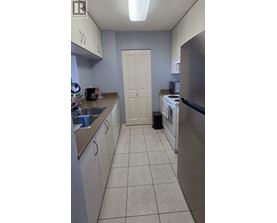 A kitchen with a white door and a stainless steel refrigerator.