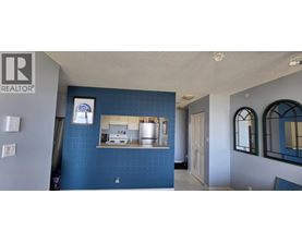 A blue wall with a mirror and a framed picture on it.