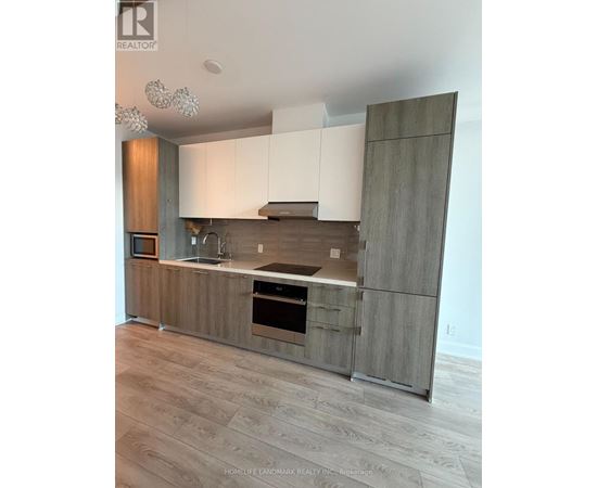A modern kitchen with wooden cabinets and a stainless steel oven.