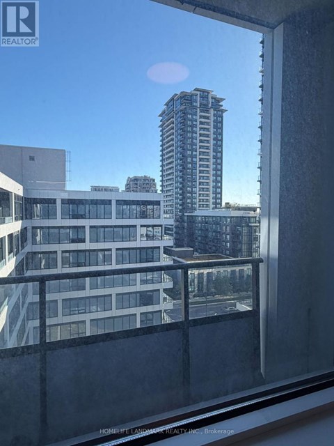 A view from a window of a cityscape with buildings and a clear sky.