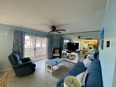 A living room with a blue couch and a ceiling fan.
