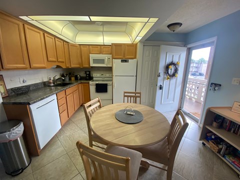 A kitchen with a table and chairs.