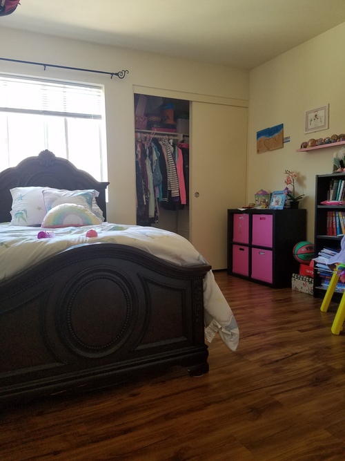 A bedroom with a bed, a wardrobe and a bookshelf.