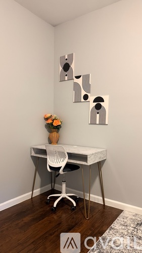 A white desk with a vase of flowers on it.