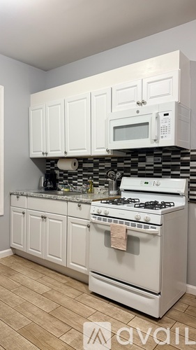 A kitchen with white cabinets and a white stove top oven.