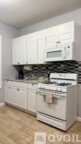 A kitchen with white cabinets and a white stove top oven.