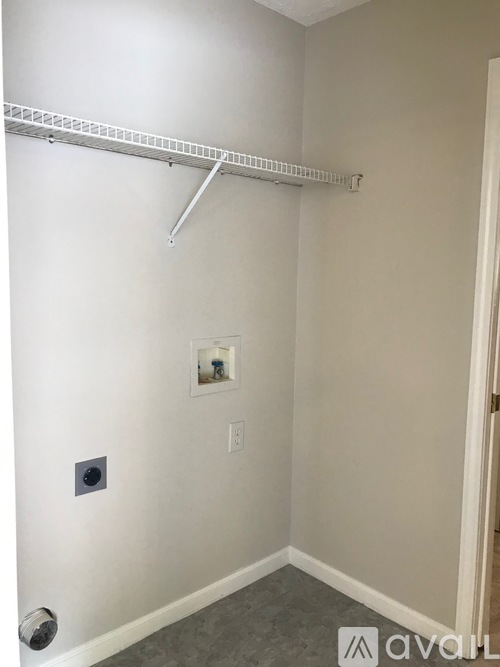 A white wall with a silver metal rod on it.