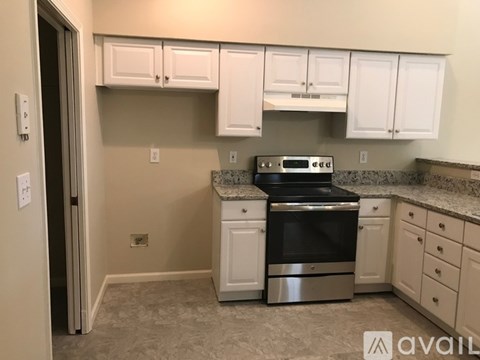 A kitchen with white cabinets and a black stove top oven.