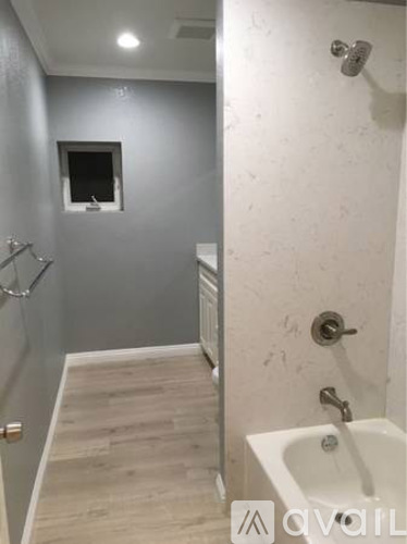 A bathroom with a sink, mirror, and shower.