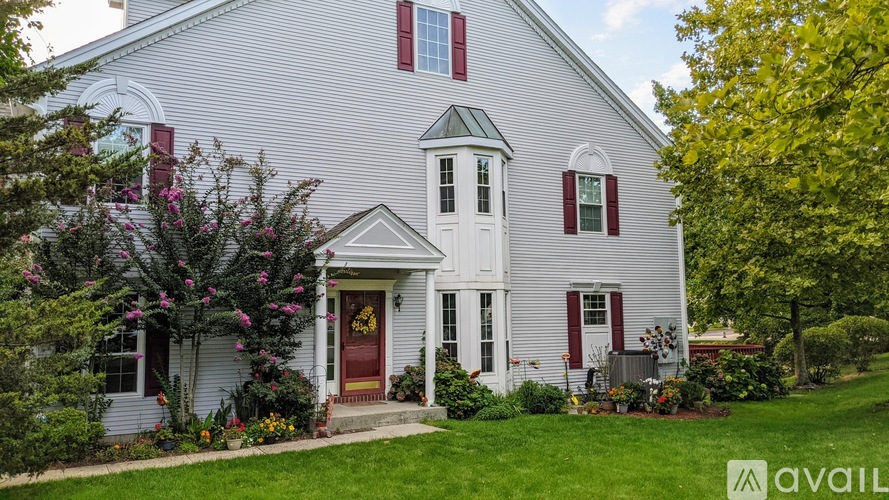 A white house with a red door and windows.
