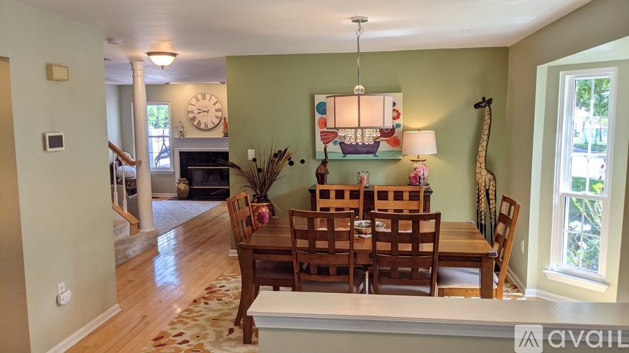 A dining room with a wooden table and chairs.