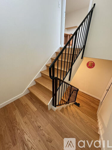 A staircase with a wooden floor and a black railing.