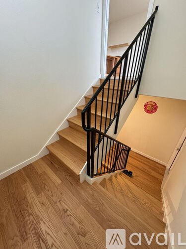 A staircase with a wooden floor and a black railing.
