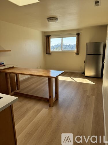 A kitchen with a table and a refrigerator.