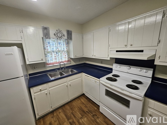 A kitchen with white cabinets and a blue countertop.