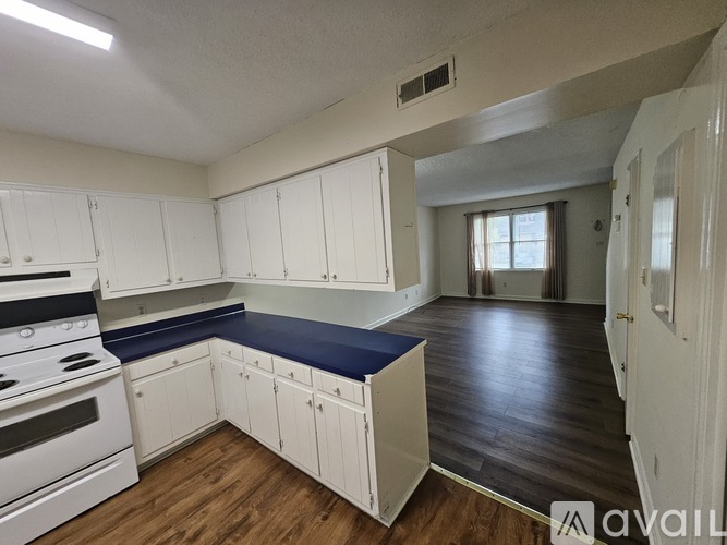 A kitchen with white cabinets and a blue countertop.