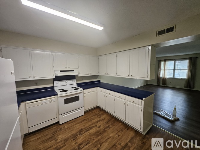 A kitchen with white cabinets and a blue countertop.