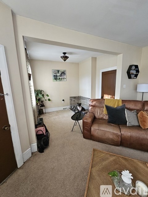 A living room with a brown couch and a coffee table.