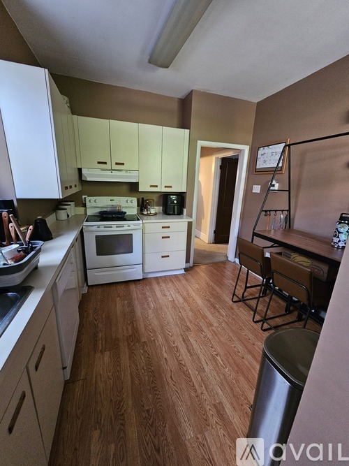 A kitchen with white cabinets and a wooden floor.