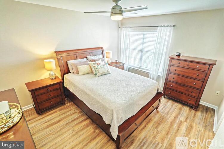 A bedroom with a bed, nightstand, and dresser.