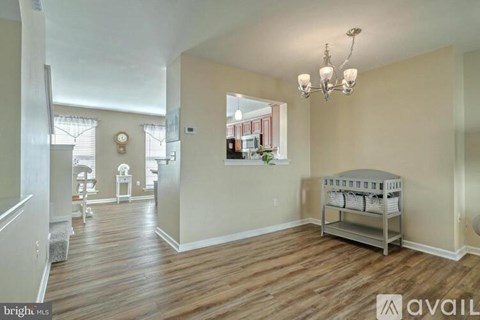 A spacious room with a crib in the corner.