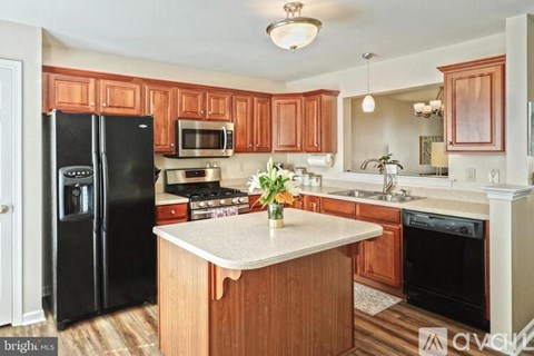 A kitchen with wooden cabinets and black appliances.