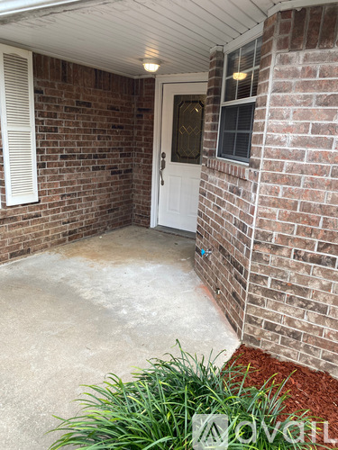 A white door is on the left side of a brick wall.