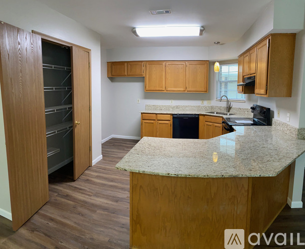 A kitchen with wooden cabinets and a granite countertop.