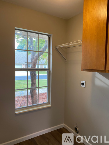 A room with a window showing a tree and a lawn outside.