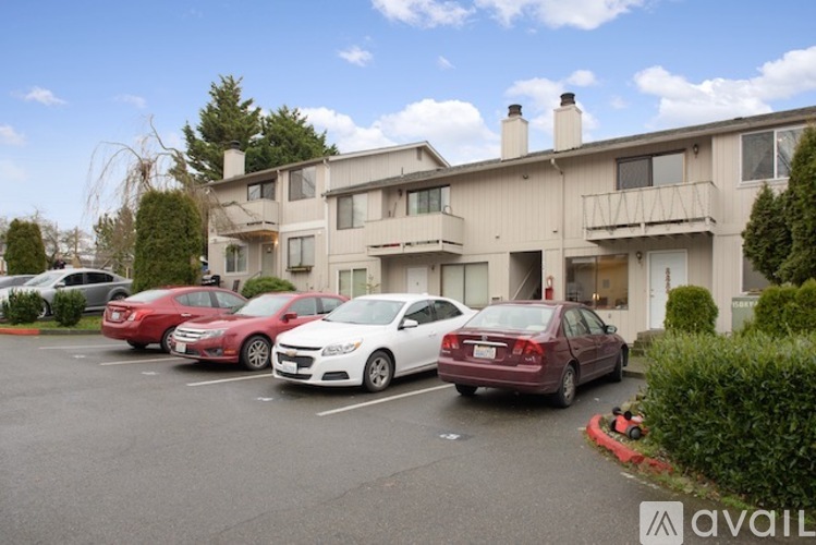A parking lot with cars and a building in the background.