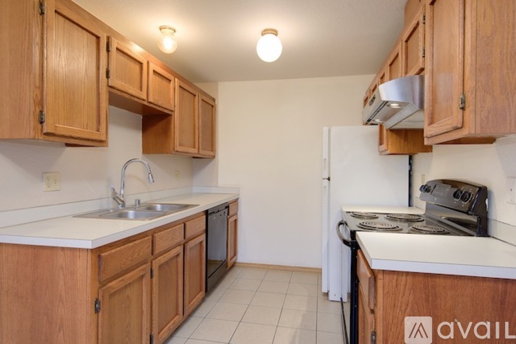 A kitchen with wooden cabinets and a white refrigerator.