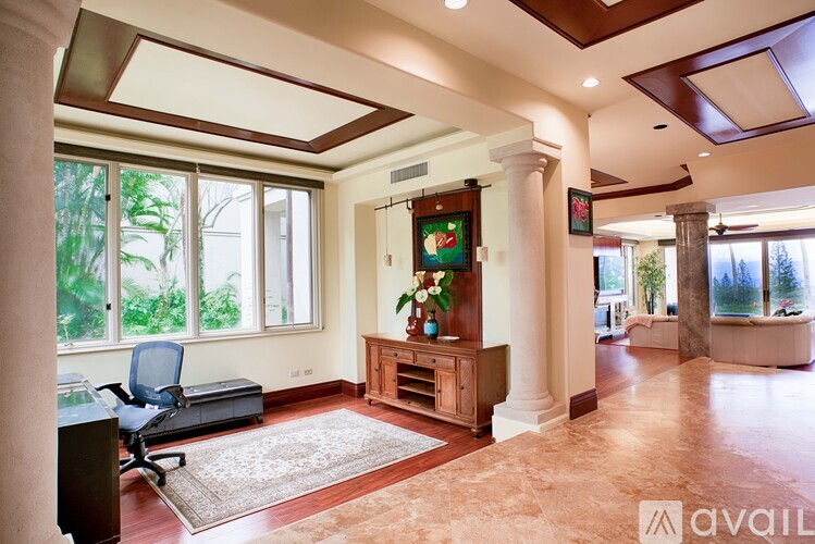 A living room with a chair, a table, and a painting on the wall.