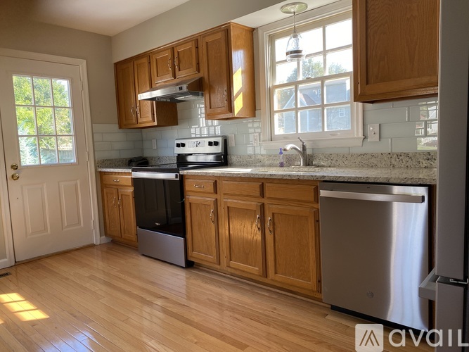 A kitchen with wooden cabinets and a stainless steel dishwasher.