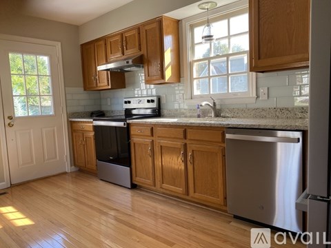 A kitchen with wooden cabinets and a stainless steel dishwasher.