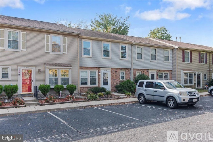 A row of townhouses with a silver SUV parked in front.
