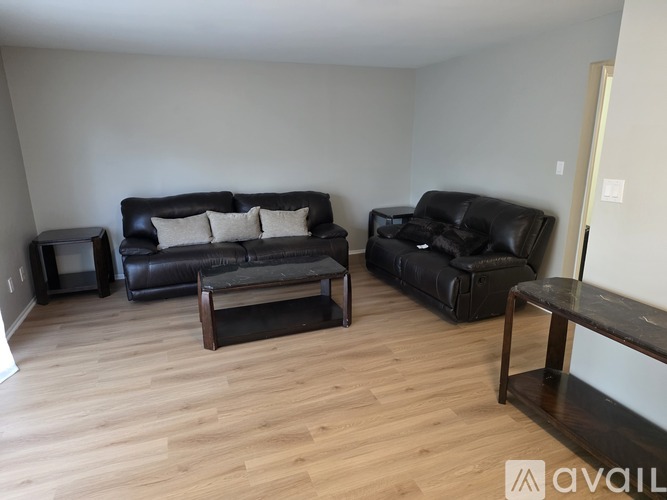 A living room with a black couch and a coffee table.