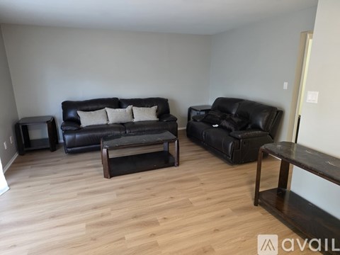 A living room with a black couch and a coffee table.