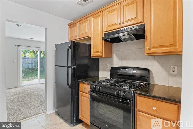 A kitchen with wooden cabinets and black appliances.