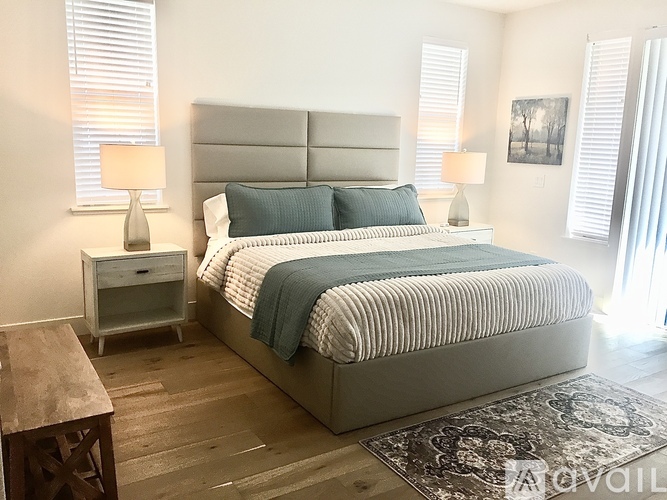 A bedroom with a large bed and a wooden nightstand.