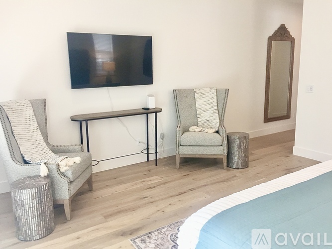 A living room with a grey chair and a white blanket on it.