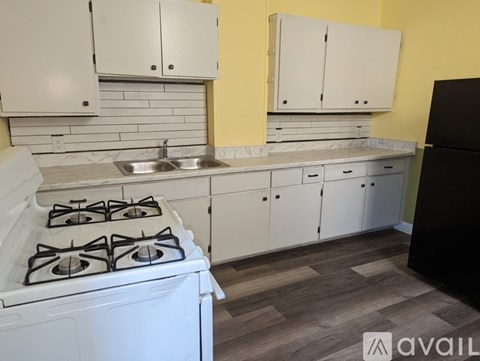 A kitchen with a white stove and cabinets.