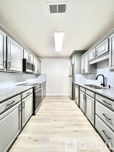 A kitchen with a long counter and cabinets.