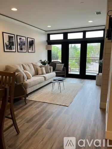 A living room with a couch, chair, and pictures on the wall.