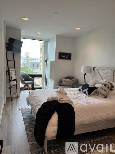 A bedroom with a large bed and a chair.